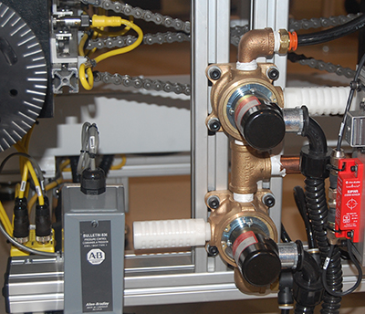 close-up of automation machine build - copper fittings, chain links in background